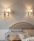 Vintage Wireless Wall Sconce Set Of Two Rechargeable Gold Led Accent Lamps With Fifteen RGB Mood Tones Zero Cord Hassle Super Easy Mount For Living Room Vibe mounted above a bed, showcasing brass finish and white shades.
