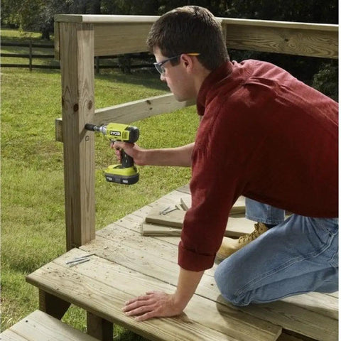 Person using Eighteen Volt Cordless Hammer Drill And Impact Driver Combo Kit for wood deck construction, black and green tools