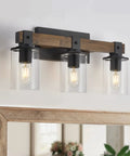 4-Light Industrial Farmhouse Vanity Lights With Rustic Wood And Clear Glass, mounted above a mirror with wooden frame.