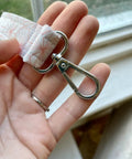 Heavy Duty Silver Swivel Lobster Clasps One Inch Metal Snap Hooks Built Boss Tough For Purses Bags And Secure Key Chains close-up view in hand.