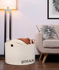 XXXL Cotton Rope Storage Basket With Handles Extra Large 22x22x14 Inches in cream beside couch with blankets.