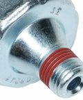 Close-up of premium engine oil pressure sender with light aftermarket replacement, showing metal build and red seal.