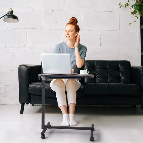 Smooth Rollin Mobile Adjustable Height Portable Computer Desk With Lockable Casters For Top Tier Home Office Standing Laptop Workstation Dark Wood Finish in use with a woman working on a laptop.