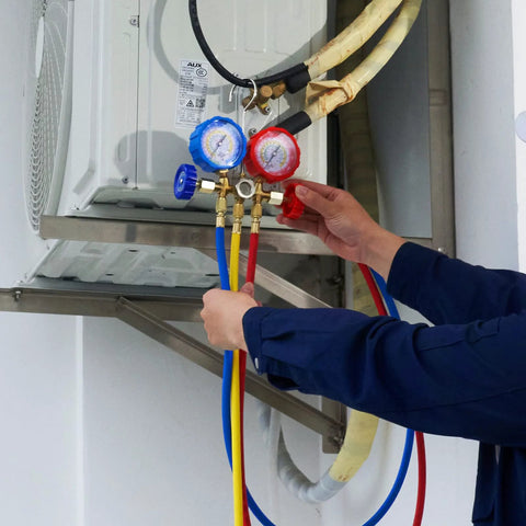 AC manifold gauge set, front view, with blue and red gauges and yellow, blue, red hoses attached