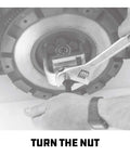 Powerbuilt pilot bearing puller in use; silver tool with wrench turning the puller bolt inside a circular flywheel housing