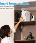 Indoor Security Camera With 360 Degree View And Auto Tracking For Home Or Pet Monitoring, placed on a shelf next to books.
