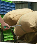 Hand using Stainless Steel Grain Sampler Tool With Handy Handle Compact Probe For Corn Rice And Wheat Sampling in a storage area