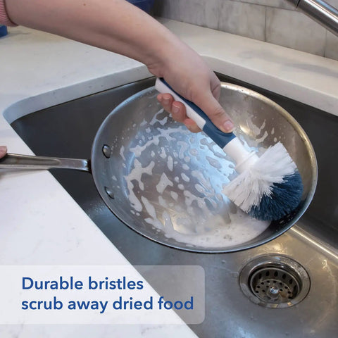 Heavy Duty Sink And Dish Scrub Brush With Safe Bristles cleaning a soapy frying pan in a kitchen sink.
