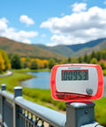 Red Portable Pedometer With Mini Digital LCD Display, All In One Step Counter For Walking And Running, Tracks Distance In Miles, Calorie Burn, Daily Target, Exercise Time, Compact And Easy To Use on railing