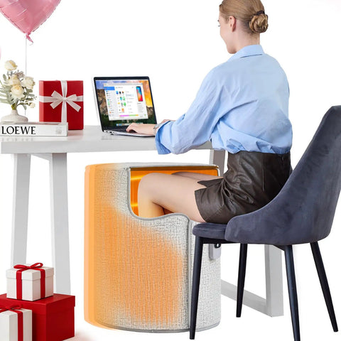 Woman using Under Desk Heater For Home Or Office Quiet Portable Space Warmer To Keep Feet And Legs Toasty as she works at a desk.