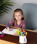 Girl writing on paper with pens on a desk in home office, near XL Desk Pad 17 X 36 Inch Large Vegan Leather Desk Mat For Home Office