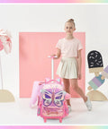 Pink rolling backpack with glitter butterfly wings; front view shows pink wheeled luggage beside girl.