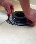 Hands placing Perfect Seal Toilet Wax Ring With Bolts No Mess Installation Repositionable Toilet Seal on bathroom floor flange.