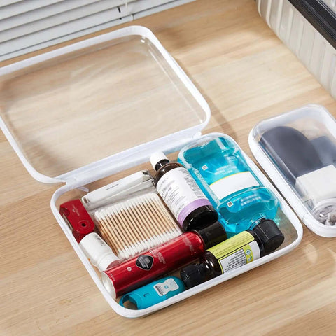 Hella Tough Four Piece Clear Hard Shell Case With Secure Zipper Closure, filled with toiletries and cosmetics, clear with white trim.