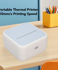 Portable pocket-sized Banapoy Inkless Bluetooth Thermal Label Maker Machine with five rolls on a wooden desk.