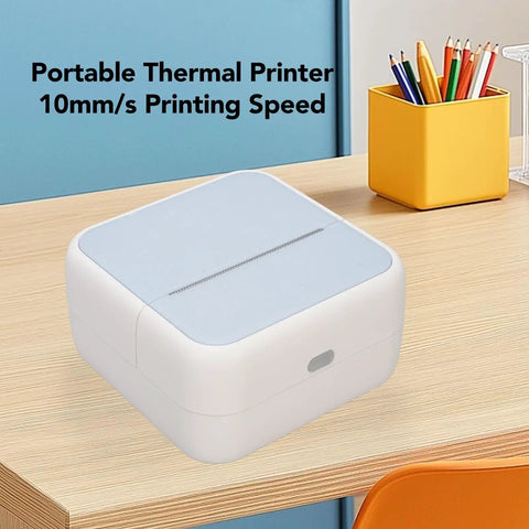 Portable pocket-sized Banapoy Inkless Bluetooth Thermal Label Maker Machine with five rolls on a wooden desk.
