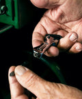 Hands holding a Compact Self Adjusting Pipe Vise With Sweet Ratchet Action and Nifty Contoured Grip for Tight Spots, showing its polished chrome finish.