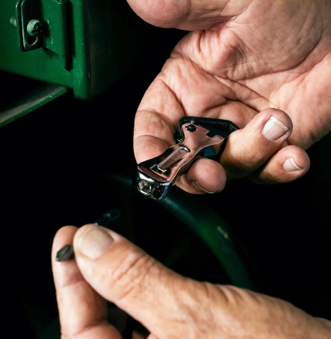 Hands holding a Compact Self Adjusting Pipe Vise With Sweet Ratchet Action and Nifty Contoured Grip for Tight Spots, showing its polished chrome finish.