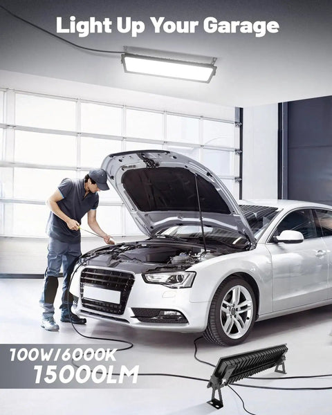 Two Pack Linkable LED Shop Lights 100W 15000LM 6000K Daylight Brightness Plug In Garage Light With 9.84ft Cord Built In Outlet for illuminating a garage with a car and mechanic.