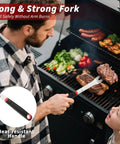 Man using heavy duty 4 piece barbecue tools set with stainless steel fork to grill steak, featuring heat-resistant handle, outdoor grill.