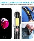 Beast Bright LED Flashlight With Magnetic Tail COB Sidelight Zoomable Beam next to phone and clipped on backpack