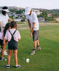 Family practicing golf on grass with Pro Grade Indoor Golf Tees For Practice Mats Pack Of 20 10 Tall And 10 Short White Tees Durable