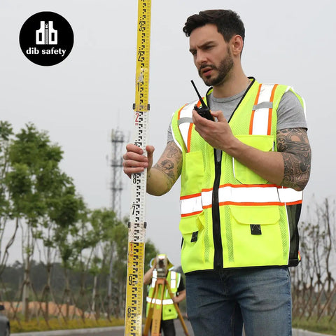 Built Tough Heavy Duty Reflective Safety Vest With 3M Tape And Reinforced Stitching Breathable Yellow Mesh Hella Visible For Construction Crews And Surveyors Zippered Front With Utility Pockets XL worn by man measuring on construction site.