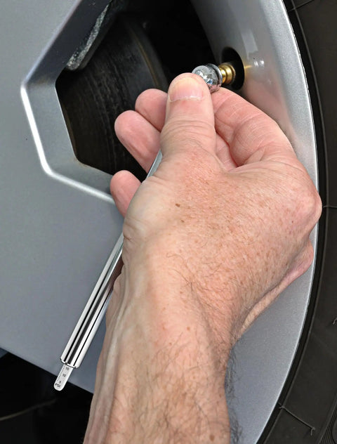 Hand using 20 Piece Must Have Air Tool Kit For Air Compressors With One Quarter Inch NPT Quick Connects Tire Gauge on wheel