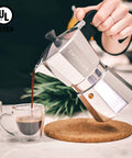 Stovetop Espresso Moka Pot For Home And Camping 6 Cup Italian Style Coffee Maker, aluminum, pouring espresso into glass cup.