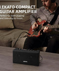 Man playing electric guitar next to Portable Mini Guitar Amplifier With Clean And Distortion Channels 5W Rechargeable Bluetooth Practice Amp For Electric Bass Small Yet Loud With Dope Tones For Daily Jams.