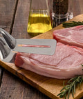 Multifunction 11 Inch Premium Stainless Steel Tongs 3 In 1 Gripper Flip And Scraper with raw meat on wooden board