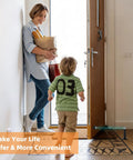 Adjustable Magnetic Door Stop Built Tough With Strong Magnetic Hold Stainless Steel Black Door Stop Wall Or Floor Mount Extends 3.15 To 4.8 Inches For A Perfect Fit And Easy Grip in use by a mom holding groceries and child entering through a door.