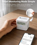 Smart WiFi Radon Detector For Home With Instant App Alerts And Continuous Daily Trend Tracking To Keep Indoor Air Crisp And Your Place Hella Safe All Year Long on wooden desk with smartphone.