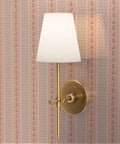 Fresh Peach Floral Stripe and Silver Metallic Wallpaper with gold sconce lamp on wall in softly lit room.