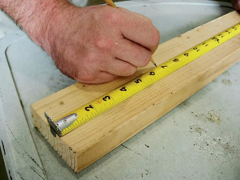 Monster Maggrip 25 Foot Measuring Tape used on wood, yellow with magnetic end, double-sided markings visible in rugged case