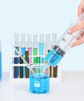 60mL Large Plastic Syringe 3 Pack With Adapter For Liquid Transfer in lab beaker with blue liquid, surrounded by glass tubes