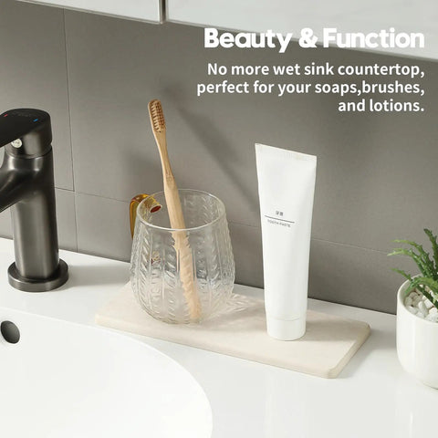 Two Pack Beige Diatomite Soap Dryers Rapid Absorbing Countertop Organizers with toothbrush and toothpaste on bathroom sink.