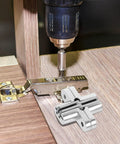 Installing Concealed Folding Cross Hinge For Wooden And Wardrobe Doors Stainless Steel with drill on wooden surface.