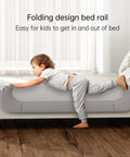 Foldable Toddler Bed Rail Guard With Bulletproof Anchor Strap And Zero Slide Base Design Heavy Duty Grey Toddler Barrier Rails For Tiny Humans Sleep Tight All Night Long with child getting in bed.