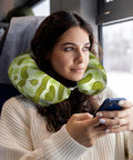 Woman using memory foam travel pillow U shaped neck support for driving and long trips with sushi dill pickles style full frame print