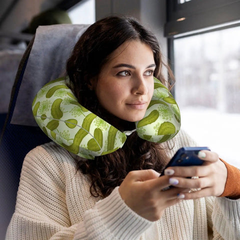 Woman using memory foam travel pillow U shaped neck support for driving and long trips with sushi dill pickles style full frame print