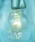 Close-up of Lagoon Mini Pendant Light With Dope Aqua Water Glass in Satin Nickel Finish, featuring lit bulb and blue glass accent.