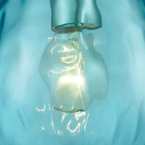 Close-up of Lagoon Mini Pendant Light With Dope Aqua Water Glass in Satin Nickel Finish, featuring lit bulb and blue glass accent.