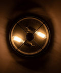 Bottom view of Industrial Black 13 Inch Flush Mount Ceiling Light With Seeded Glass Shade And Metal Cage For Kitchen Dining Room Foyer And Hallway Dope Vintage Farmhouse Vibe Ceiling Fixture illuminated in a warm glow.