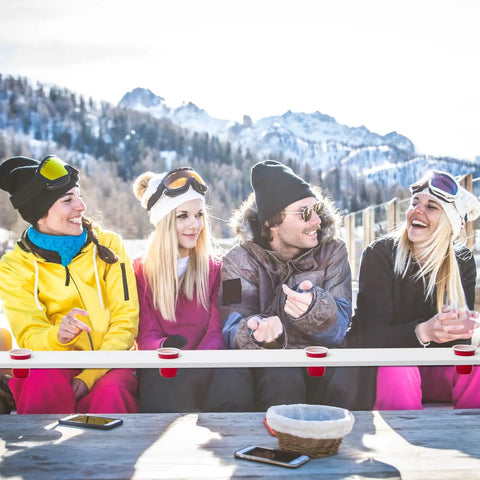 Rustic White Wooden Ski Shot Board Set For Four Players Pub Trivia Drinking Game With Fifty Marked Cups And Included Marking Pen in use outdoors.