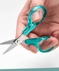 Curved And Straight Craft Scissors Set For Embroidery And Sewing, Multipurpose Stainless Steel With Protective Covers, Green And Purple Handles, Ideal For Paper Cutting, Detailing, And DIY Craft Projects. Hand holding turquoise straight craft scissors.