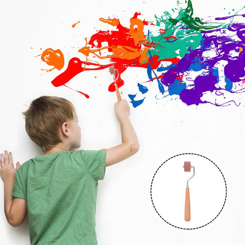 Boy using a Professional Heavy Duty Rubber Ink Roller For Printmaking And Canvas Painting Smooth Glide Surface on a wall.
