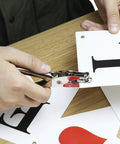 Person using 24 Pack One Quarter Inch Single Hole Puncher Set With 5 Sheet Capacity, Metal Construction, Built In Confetti Storage on paper.