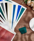 PLIGREAT 12-color marking paper sheets, front view, fanned on wood desk with teal scraper