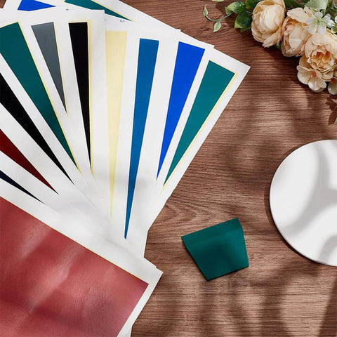 PLIGREAT 12-color marking paper sheets, front view, fanned on wood desk with teal scraper